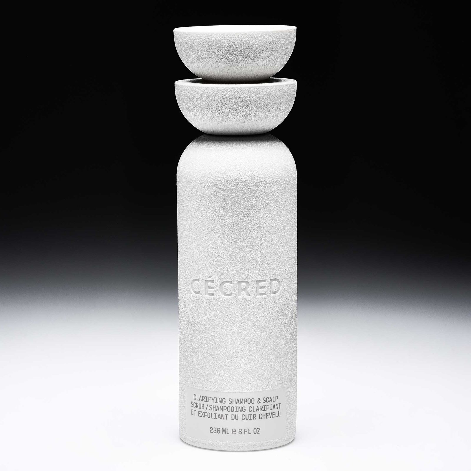 Cécred Clarifying Shampoo & Scalp Scrub 8 fl oz bottle with dual bowl cap displayed upright against a gradient black-to-white background
