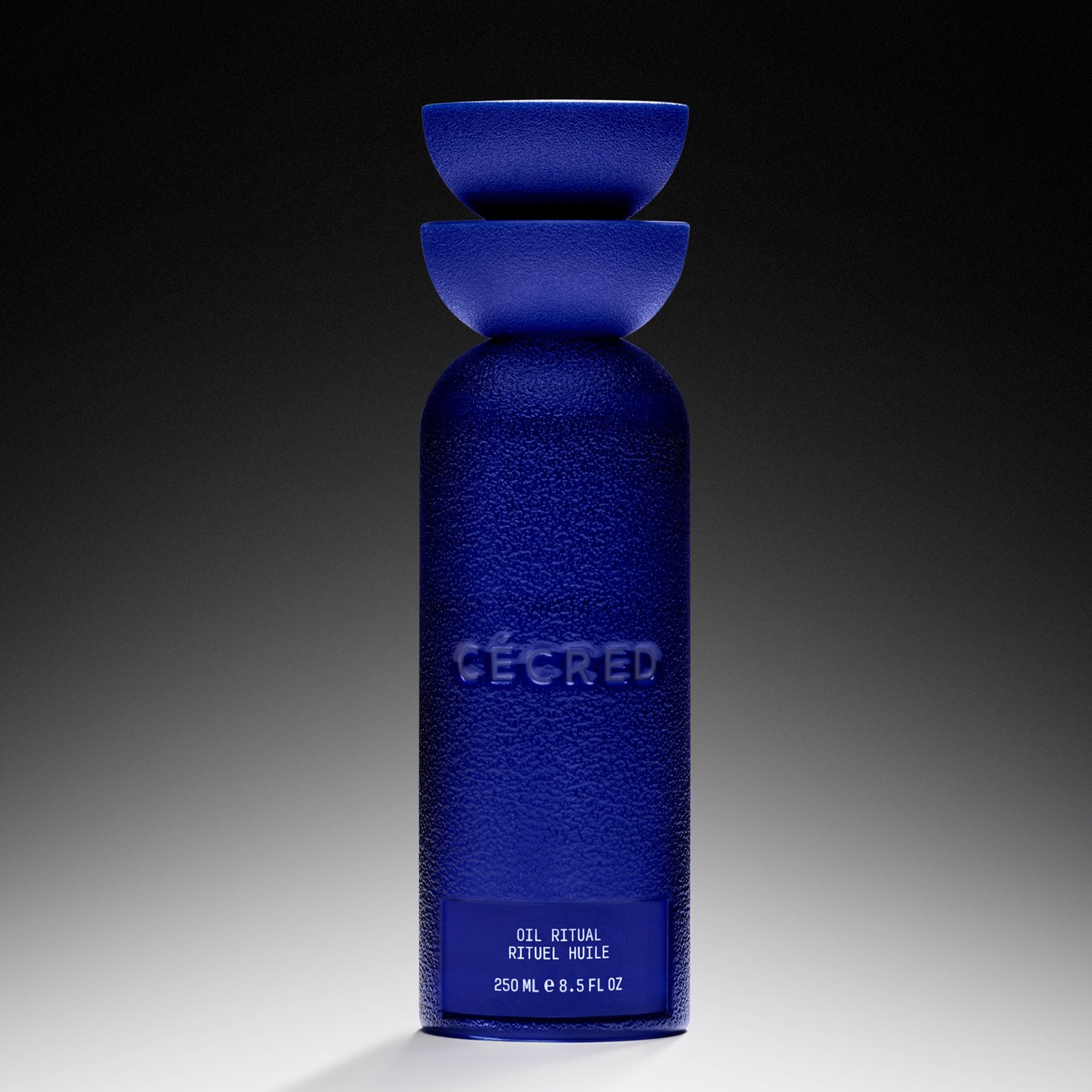 Cécred Oil Ritual — blue bottle with textured surface and Cécred branding on a gradient background