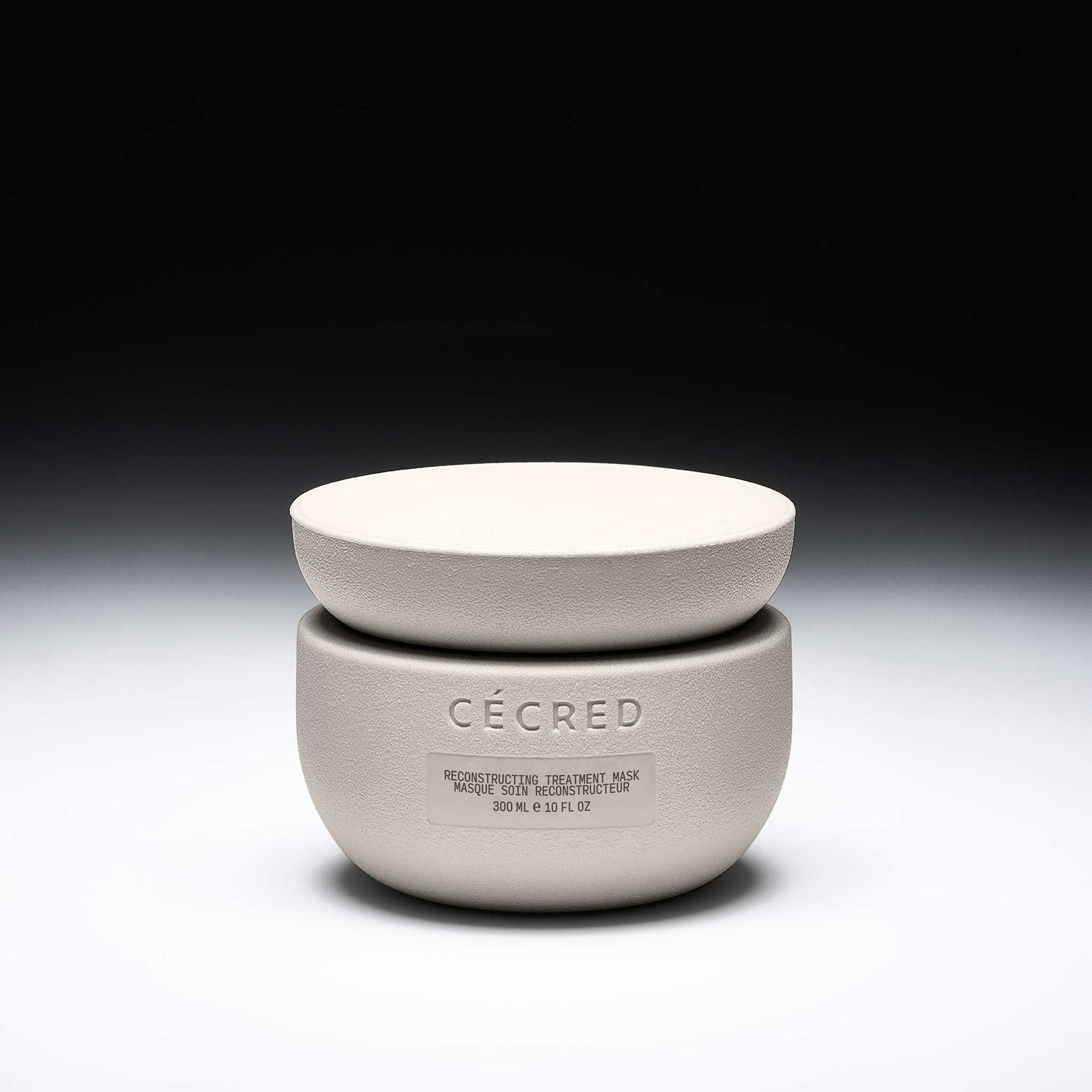 Cécred Reconstructing Treatment Mask 10 fl oz jar displayed against a gradient black-to-white background