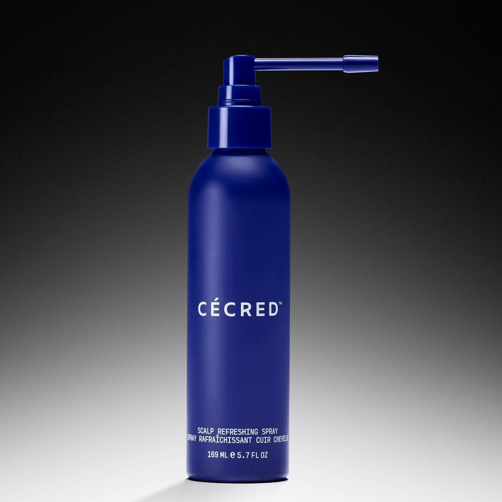 Cécred Scalp Refreshing Spray in a blue bottle on a gradient background